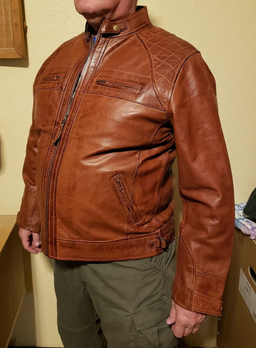 Brown leather jacket worn by a person against a neutral background